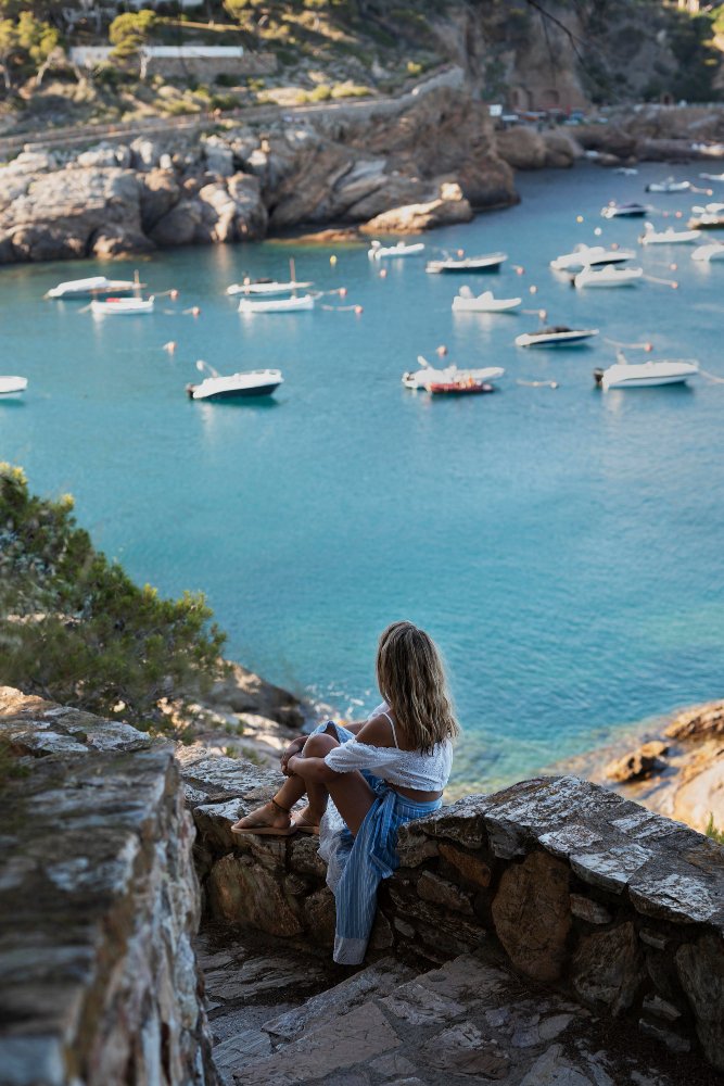 Woman enjoying a quiet viewpoint over a turquoise cove in Mallorca
